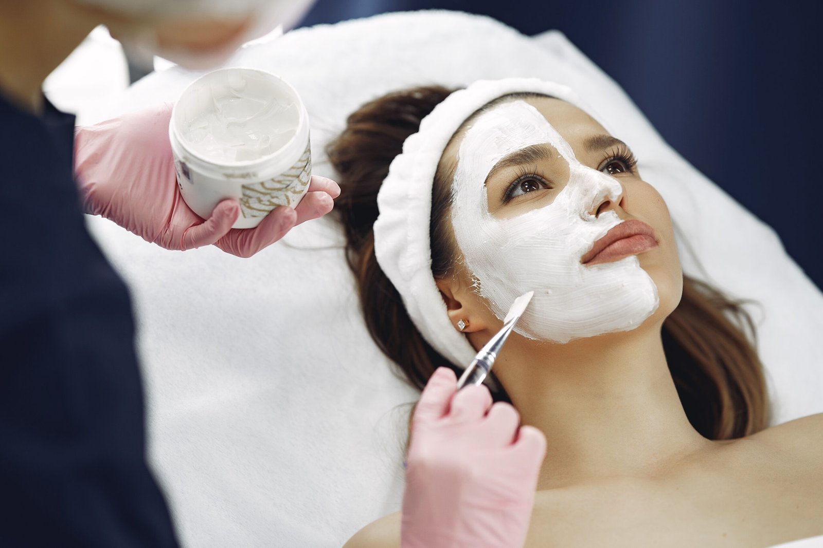 Cosmetologist treats client's skin. Woman with cosmetologist. Lady in a beauty studio.